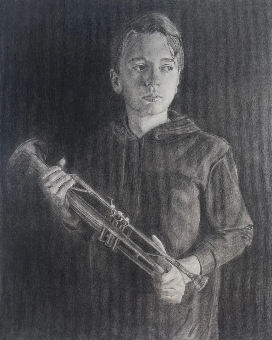 Charcoal portrait of a boy in a hooded sweatshirt holding a trumpet across his body, emerging from a dark ground.