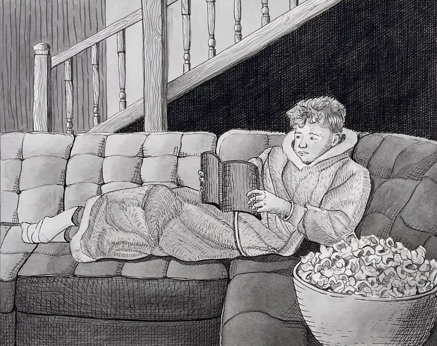 Pen and ink drawing of a boy lying along a couch reading an open book, with a bowl of popcorn on the floor and a staircase behind.