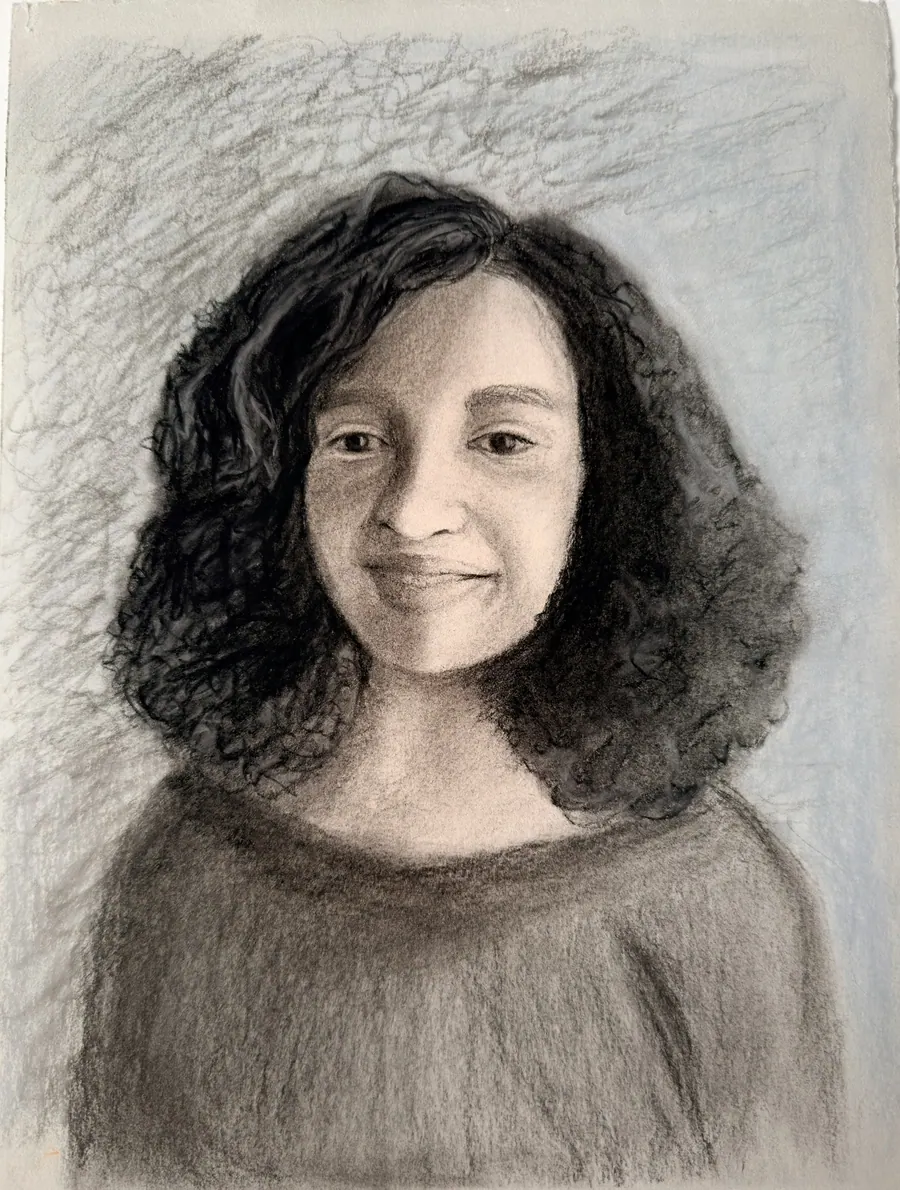 Charcoal and pastel portrait of a smiling woman with dark curly hair in a soft wide-necked sweater, against a pale blue ground.